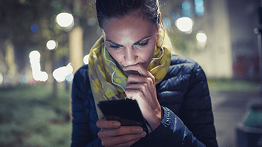 woman looking at her phone at night