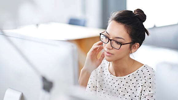 Woman in glasses sitting at computer Woman in glasses sitting at computer