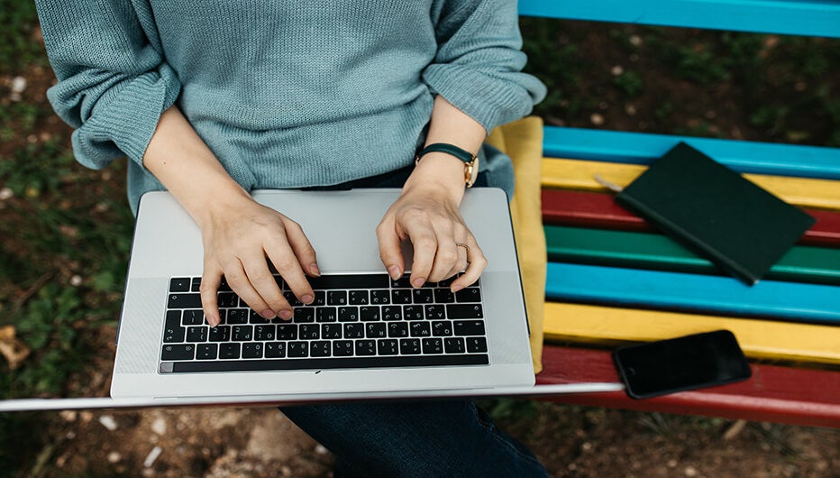 sitting in a colorful bench with laptop